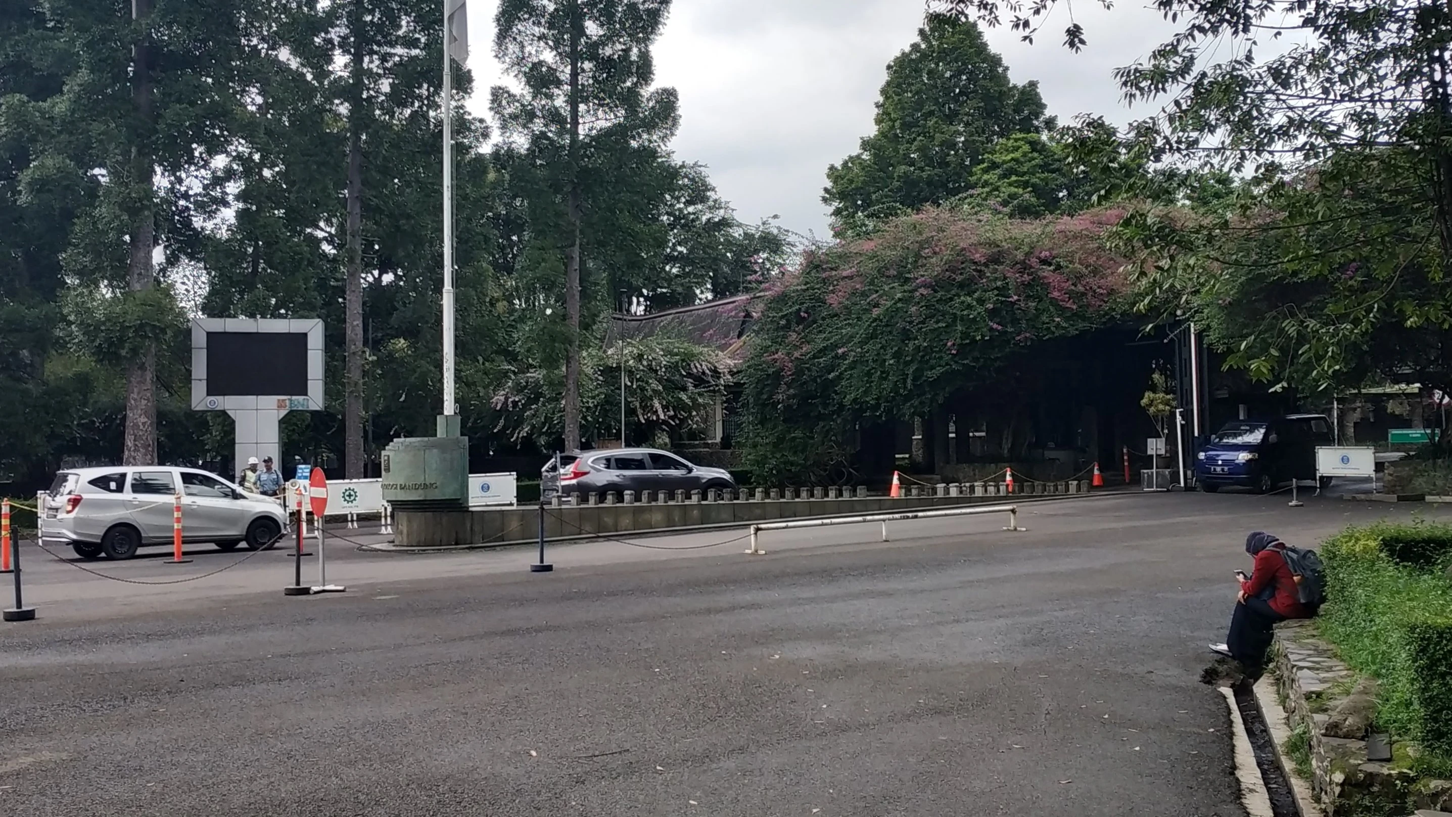 pemandangan gerbang kampus ITB dan seorang wanita yang seperti menatap kosong ke depan